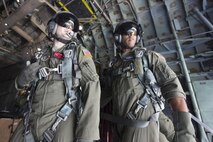(Left to right) Staff Sgt. Joel Powell, 374th Operations Support Squadron, and Chief Master Sgt. Troy Coville, Pacific Air Forces, watch a low-cost, low-altitude bundle as it drops to Angaur island, Republic of Palau, Dec. 11, 2015, during Operation Christmas Drop. This is a PACAF event which includes a partnership between the 374th Airlift Wing, Yokota Air Base, Japan; the 36th Wing, Andersen Air Force Base, Guam; the 734th Air Mobility Squadron, Andersen AFB of the 515th Air Mobility Operations Wing, Joint Base Pearl Harbor-Hickam. Hawaii; the University of Guam; and the Operation Christmas Drop private organization. It is the longest-running Department of Defense humanitarian airdrop operation with 2015 being the first trilateral execution with support from Japan Air Self-Defense Force and Royal Australian Air Force. (U.S. Air  Force photo by Osakabe Yasuo/Released)