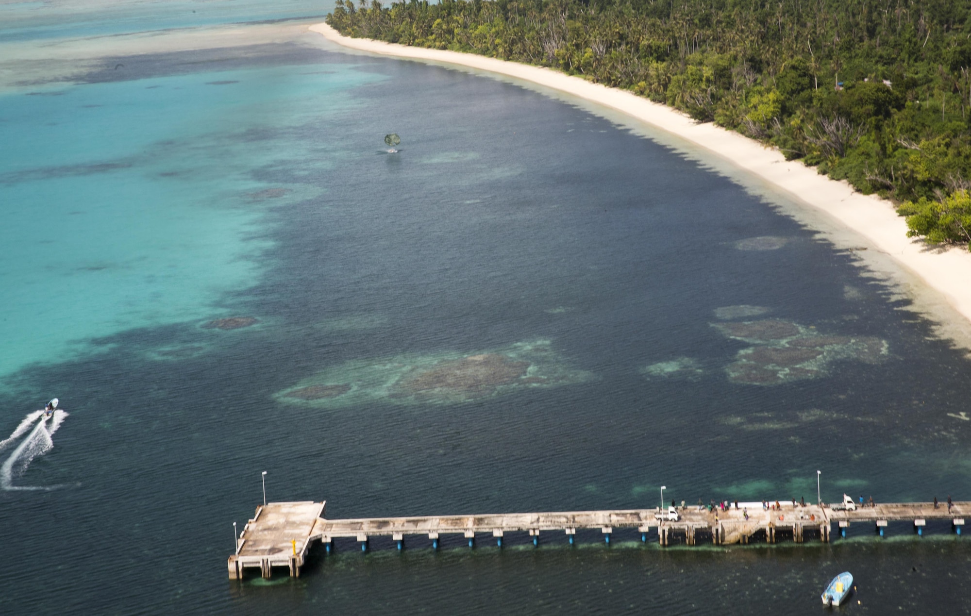 A low-cost, low-altitude bundle containing supplies, educational materials, toys and other donated goods, dropped from a U.S. C-130, floats toward Kayangel, Republic of Palau, bringing holiday cheer Dec. 11, 2015 during Operation Christmas Drop. This year marks the 64th year of Operation Christmas Drop, which began in 1952, and is the first trilateral execution of the event with support from Japan Air Self-Defense Force and Royal Australian Air Force. (U.S. Air Force photo by Osakabe Yasuo/Released)