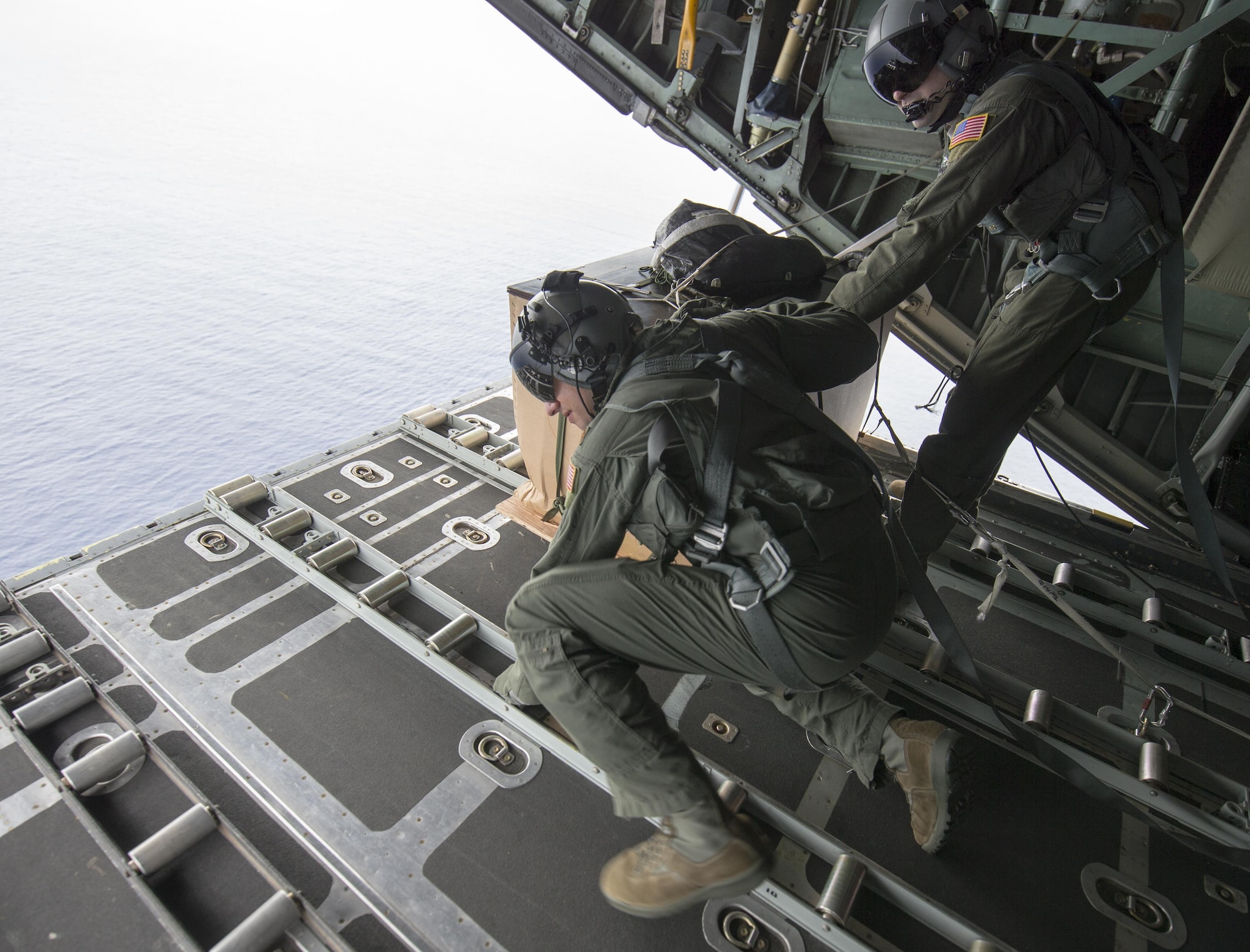 Maj. Bryan Huffman, left, Pacific Air Forces C-130 pilot, checks a drop zone over Ngulu island, Federated States of Micronesia, Dec. 11, 2015, during Operation Christmas Drop. This year marks the 64th year of Operation Christmas Drop and the first time international partners joined in execution through Japan Air Self-Defense Force and Royal Australian Air Force C-130 support. The event provides critical supplies to 56 Micronesian islands impacting about 20,000 people covering 1,000 by 1,800 nautical miles of operation area. (U.S. Air Force photo by Osakabe Yasuo/Released)