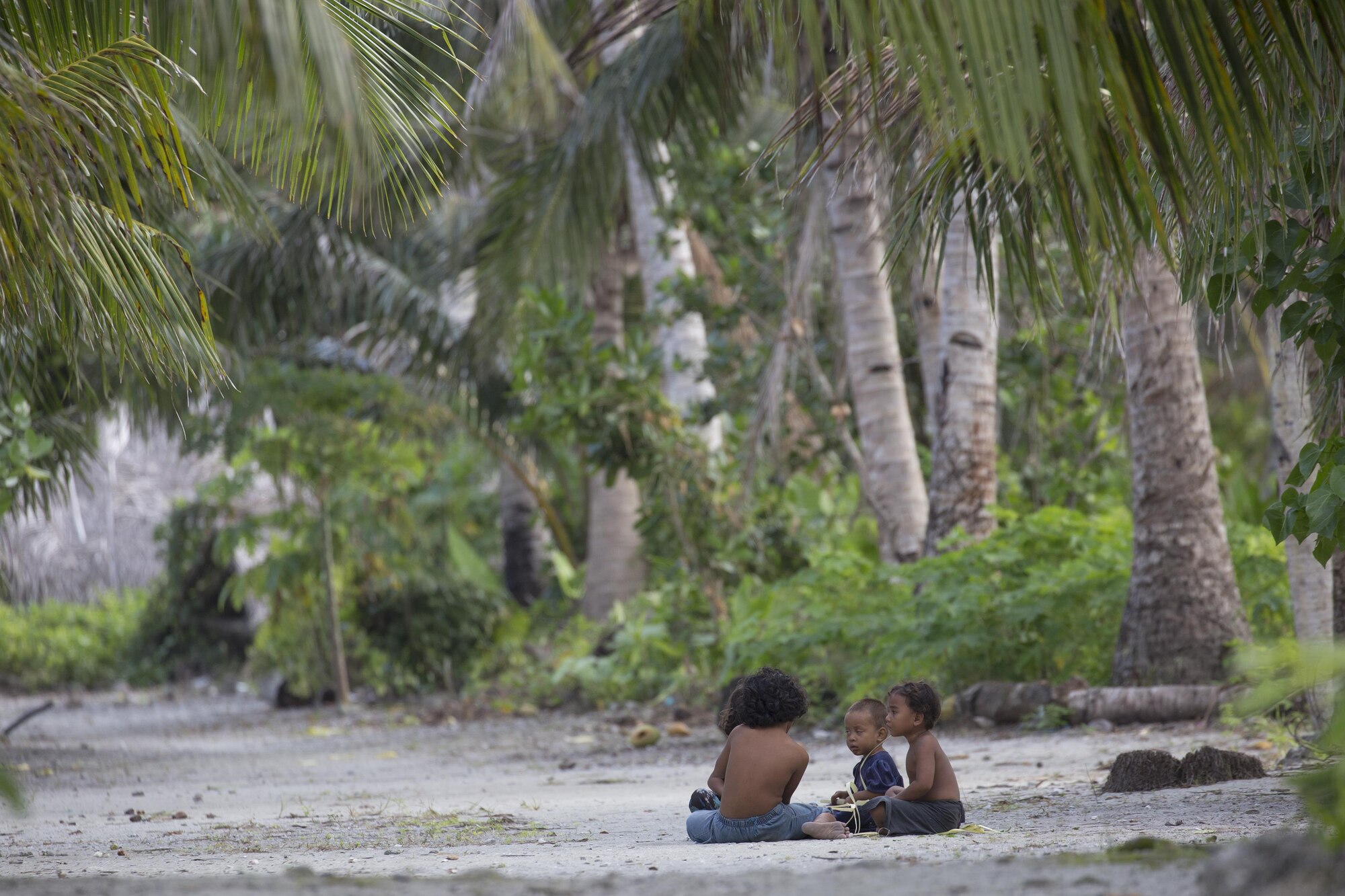 Kids sit under shade at Fais Island, Federated Sates of Micronesia, Dec. 8, 2015, during Operation Christmas Drop 2015. A C-130 Hercules from the 36th Airlift Squadron delivered more than 800 pounds of supplies to Fais island during Operation Christmas Drop 2015. This year marks the first trilateral execution that includes air support from the Japan Air-Self Defense force and the Royal Australian Air Force. (U.S. Air Force photo by Osakabe Yasuo/Released)