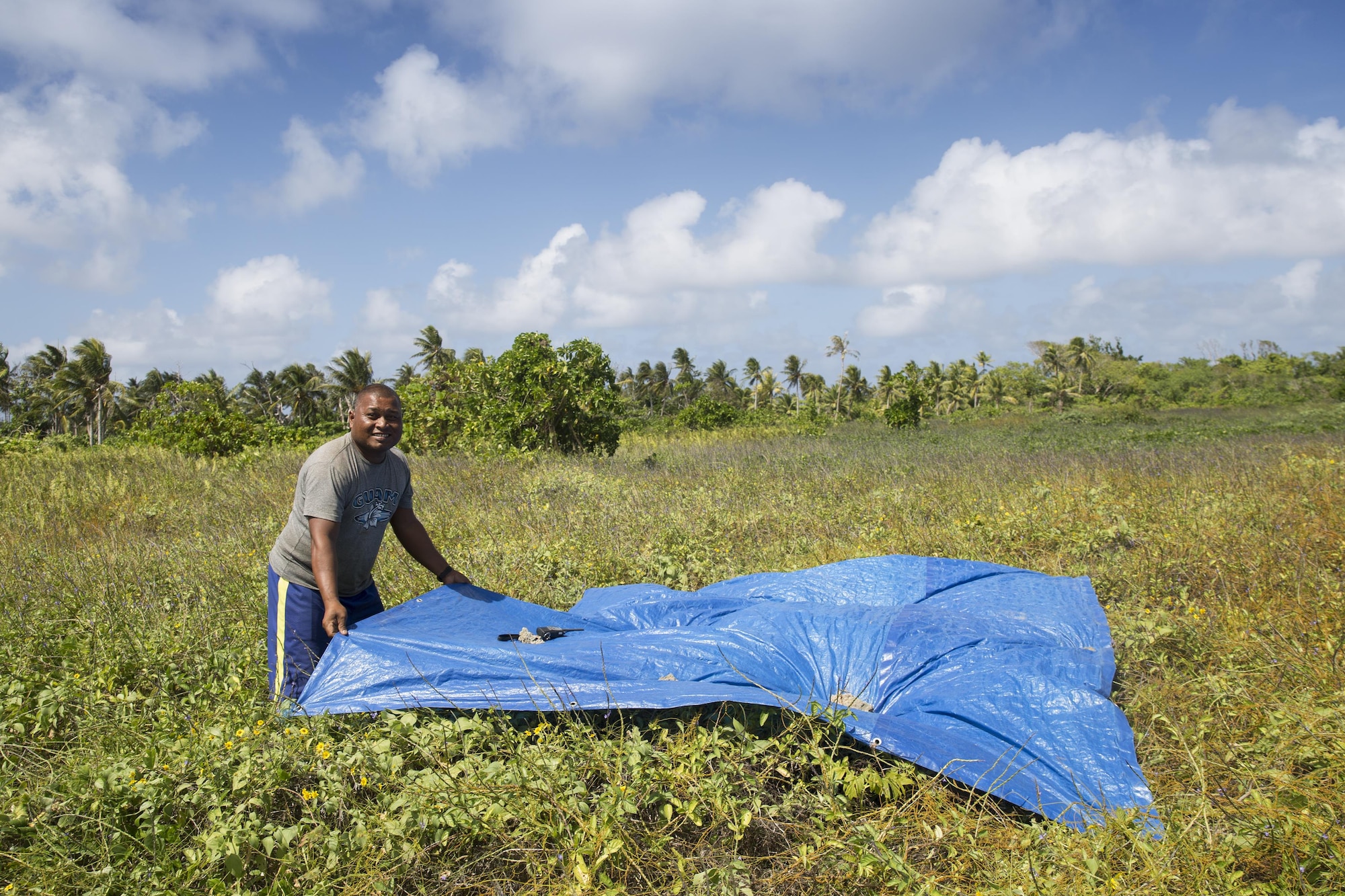 A man sets up a drop zone for a C-130 Hercules from the Yokota Air Base, Japan, Dec. 8, 2015, during Operation Christmas Drop 2015. A C-130H from the 36th Airlift Squadron delivered over 800 pounds of supplies to Fais island during Operation Christmas Drop 2015. This year marks the first ever trilateral execution that includes air support from the Japan Air-Self Defense force and the Royal Australian Air Force. (U.S. Air Force photo by Osakabe Yasuo/Released)