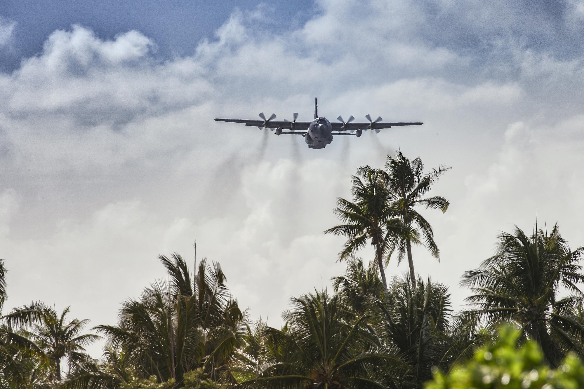 A C-130 Hercules from the 36th Airlift Squadron flies over Fais Island, Dec. 8, 2015, during Operation Christmas Drop 2015. Airmen from the Yokota delivered over 800 pounds of supplies to the island of Fais during Operation Christmas Drop 2015. This year marks the first ever trilateral Operation Christmas Drop where the U.S. Air Force, Japan Air Self-Defense Force and the Royal Australian Air Force work together to provide critical supplies to 56 Micronesian Islands. (U.S. Air Force photo by Osakabe Yasuo/Released)
