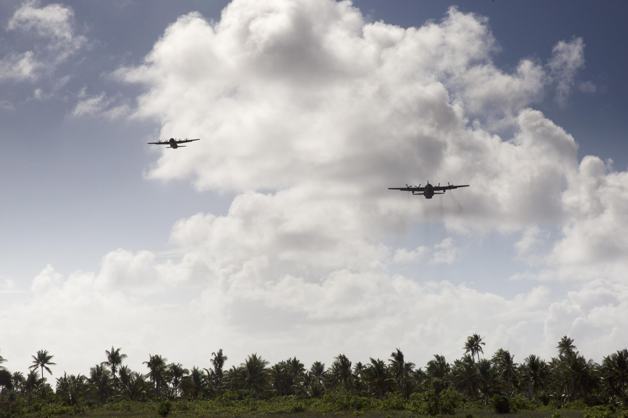 (Left) A Royal Australian Air Force C-130 J Super Hercules and a U.S. Air Force C-130 Hercules from the Yokota Air Base, Japan fly over Fais island, Federated States of Micronesia, Dec. 8, 2015, during Operation Christmas Drop 2015. A  Hercules assigned by the 36th Airlift Squadron delivered over 800 pounds of supplies to Fais Island during Operation Christmas Drop 2015. This year marks the first ever trilateral Operation Christmas Drop where the U.S. Air Force, Japan Air Self-Defense Force and the Royal Australian Air Force work together to provide critical supplies to 56 Micronesian islands.(U.S. Air Force photo by Osakabe Yasuo/Released)