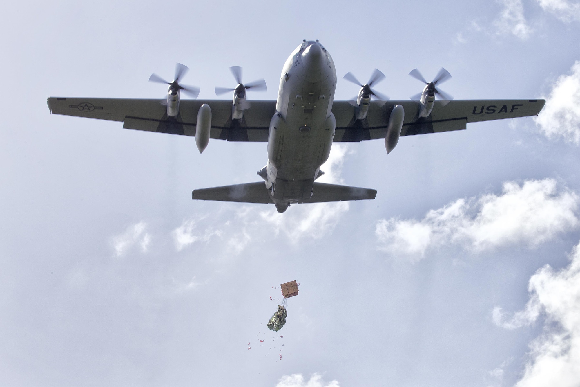 A C-130 Hercules assigned to the 36th Airlift Squadron drops a bundle filled with donated goods and supplies during Operation Christmas Drop 2015, at Fais Island, Federated States of Micronesia, Dec. 8, 2015. Airmen delivered over 800 pounds of supplies to the island of Fais during the drop. This year marks the first trilateral Operation Christmas Drop where the U.S. Air Force, Japan Air Self-Defense Force and the Royal Australian Air Force work together to provide critical supplies to 56 Micronesian islands impacting 20,000 islanders. (U.S. Air Force photo by Osakabe Yasuo/Released)