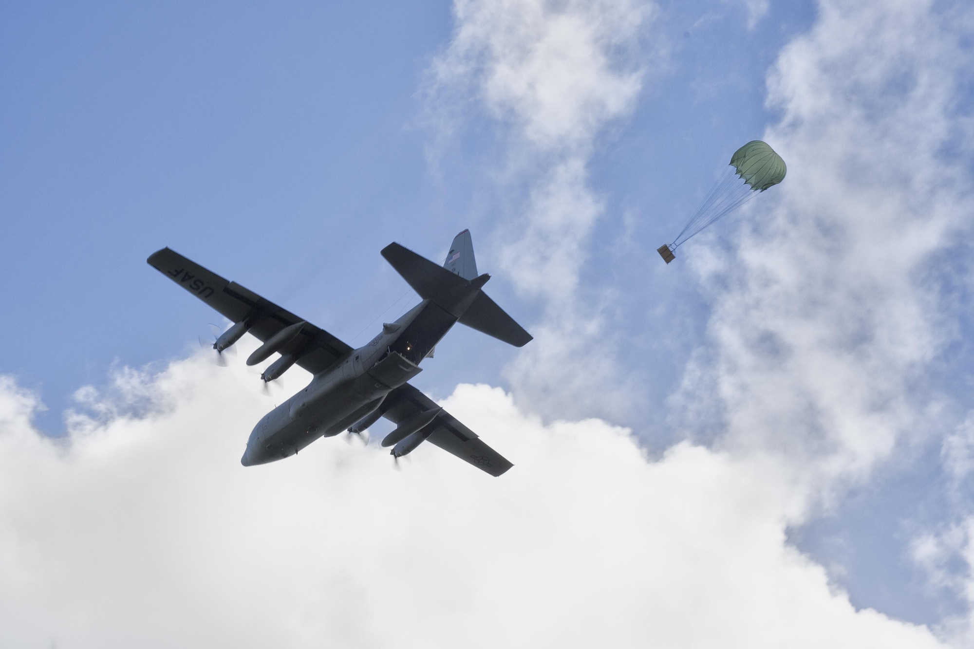 A C-130 Hercules assigned to the 36th Airlift Squadron drops a bundles during Operation Christmas Drop 2015, at Fais Island, Federated States of Micronesia, Dec. 8, 2015. Airmen delivered over 800 pounds of supplies to the island of Fais during Operation Christmas Drop 2015. This year marks the first trilateral Operation Christmas Drop where the U.S. Air Force, Japan Air Self-Defense Force and the Royal Australian Air Force work together to provide critical supplies to 56 Micronesian islands. (U.S. Air Force photo by Osakabe Yasuo/Released)