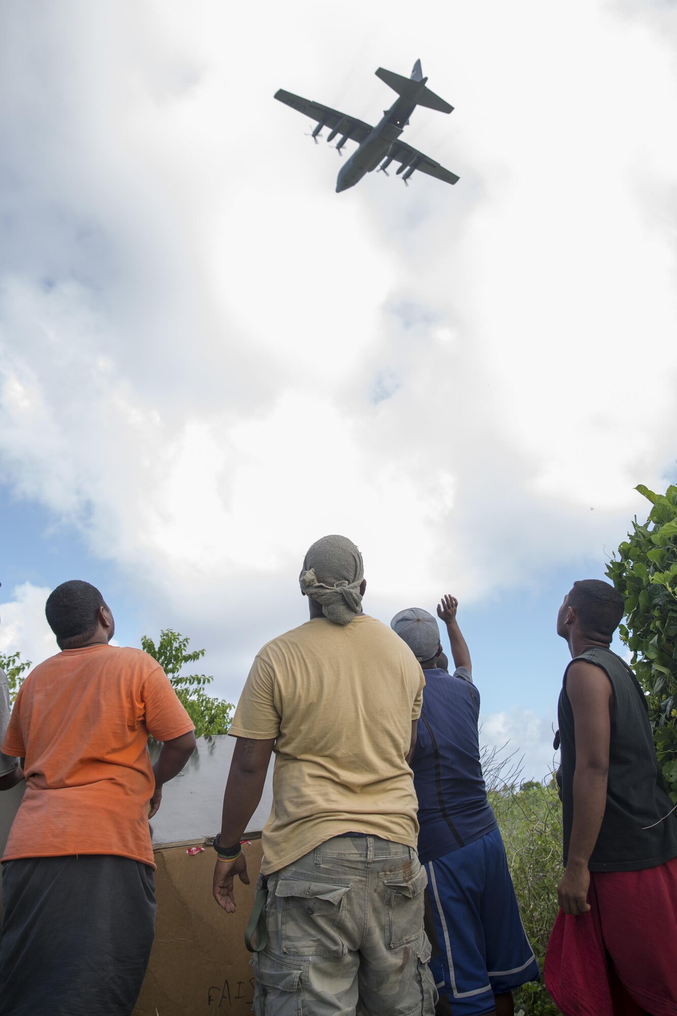 Islanders on Fais island, Federated States of Micronesia, wave to the aircrew of a C-130 Hercules assigned to the 36th Airlift Squadron after dropping a bundle of donated goods and supplies during Operation Christmas Drop 2015, Dec. 8, 2015. Airmen delivered over 800 pounds of supplies to the island of Fais during Operation Christmas Drop 2015. This year marks the first trilateral Operation Christmas Drop where the U.S. Air Force, Japan Air Self-Defense Force and the Royal Australian Air Force work together to provide critical supplies to 56 Micronesian islands impacting 20,000 islanders. (U.S. Air Force photo by Osakabe Yasuo/Released)