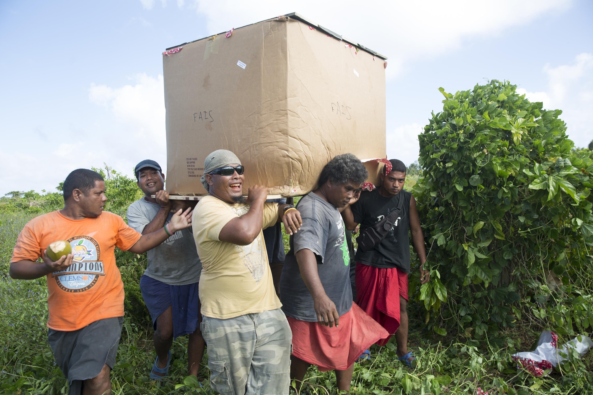 Locals from the island of Fais recover and carry a low-cost, low-altitude bundle during Operation Christmas Drop 2015. Operation Christmas Drop is the Department of Defense's longest running humanitarian airdrop mission. This year marks the first ever trilateral Operation Christmas Drop where the U.S. Air Force, Japan Air Self-Defense Force and the Royal Australian Air Force work together to provide critical supplies to 56 Micronesian islands. (U.S. Air Force photo by Osakabe Yasuo/Released)