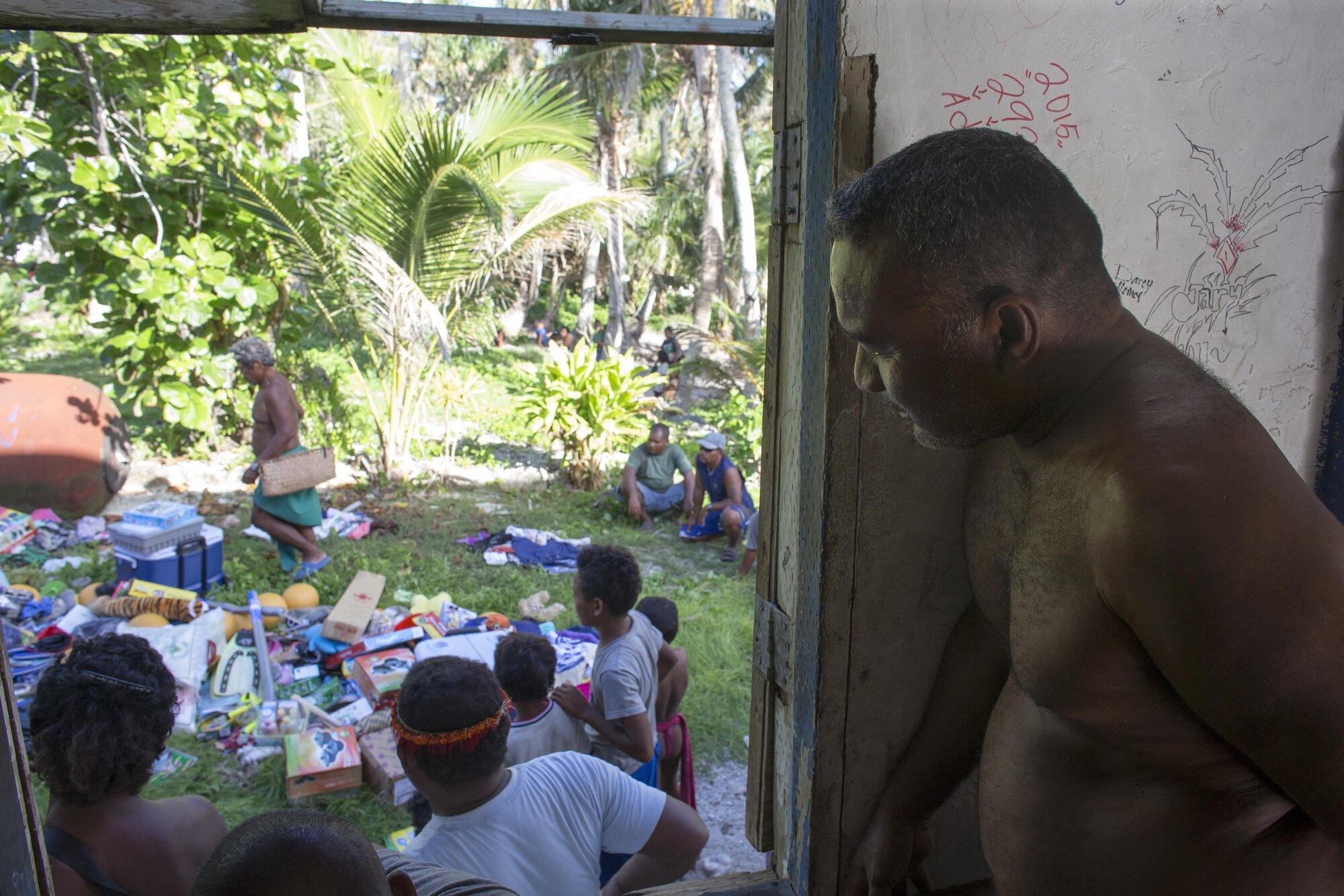 A local villager watches as Louis Mangtau, Chief of Fais Island, sorts through supplies that were dropped during Operation Christmas Drop 2015, Dec. 8, 2015, at Fais Island, Federated States of Micronesia. Operation Christmas Drop is a humanitarian/disaster relief training event where C-130 crews provide critical supplies to 56 islands throughout the Commonwealth of the Northern Marianas, Federated States of Micronesia and Republic of Palau.This year marks the first ever trilateral execution that includes air support from the U.S. Air Force, Japan Air Self-Defense Force and the Royal Australian Air Force. (U.S. Air Force photo by Osakabe Yasuo/Released)