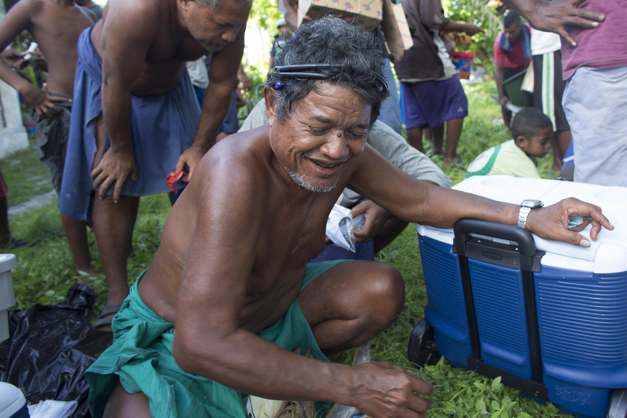 Louis Mangtau, chief of Fais Island, smiles as he sorts through supplies that were dropped during Operation Christmas Drop 2015, Dec. 8, 2015, at Fais Island, Federated States of Micronesia. Operation Christmas Drop is a humanitarian/disaster relief training event where C-130 crews provide critical supplies to 56 islands throughout the Commonwealth of the Northern Marianas, Federated States of Micronesia and Republic of Palau. This year marks the first ever trilateral execution that includes air support from the U.S. Air Force, Japan Air Self-Defense Force and the Royal Australian Air Force. (U.S. Air Force photo by Osakabe Yasuo/Released)