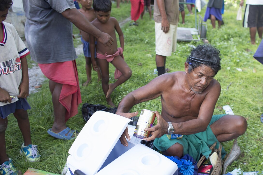Louis Mangtau, chief of Fais Island, sorts through supplies that were dropped during Operation Christmas Drop 2015, Dec. 8, 2015, at Fais Island, Federated States of Micronesia. Operation Christmas Drop is a humanitarian/disaster relief training event where C-130 crews provide critical supplies to 56 islands throughout the Commonwealth of the Northern Marianas, Federated States of Micronesia and Republic of Palau. This year marks the first ever trilateral execution that includes air support from the U.S. Air Force, Japan Air Self-Defense Force and the Royal Australian Air Force. (U.S. Air Force photo by Osakabe Yasuo/Released)