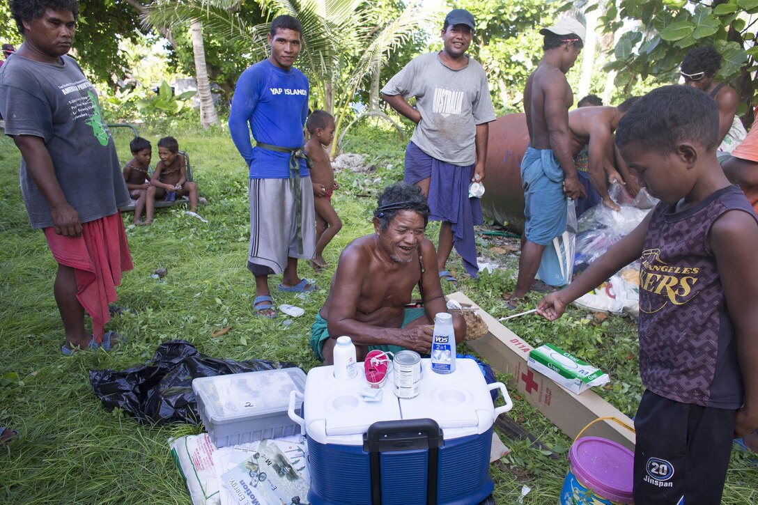 Louis Mangtau, chief of Fais Island, smiles as he sorts through supplies that were dropped during Operation Christmas Drop 2015, Dec. 8, 2015, at Fais Island, Federated States of Micronesia. Operation Christmas Drop is a humanitarian/disaster relief training event where C-130 crews provide critical supplies to 56 islands throughout the Commonwealth of the Northern Marianas, Federated States of Micronesia and Republic of Palau. This year marks the first ever trilateral execution that includes air support from the U.S. Air Force, Japan Air Self-Defense Force and the Royal Australian Air Force. (U.S. Air Force photo by Osakabe Yasuo/Released)