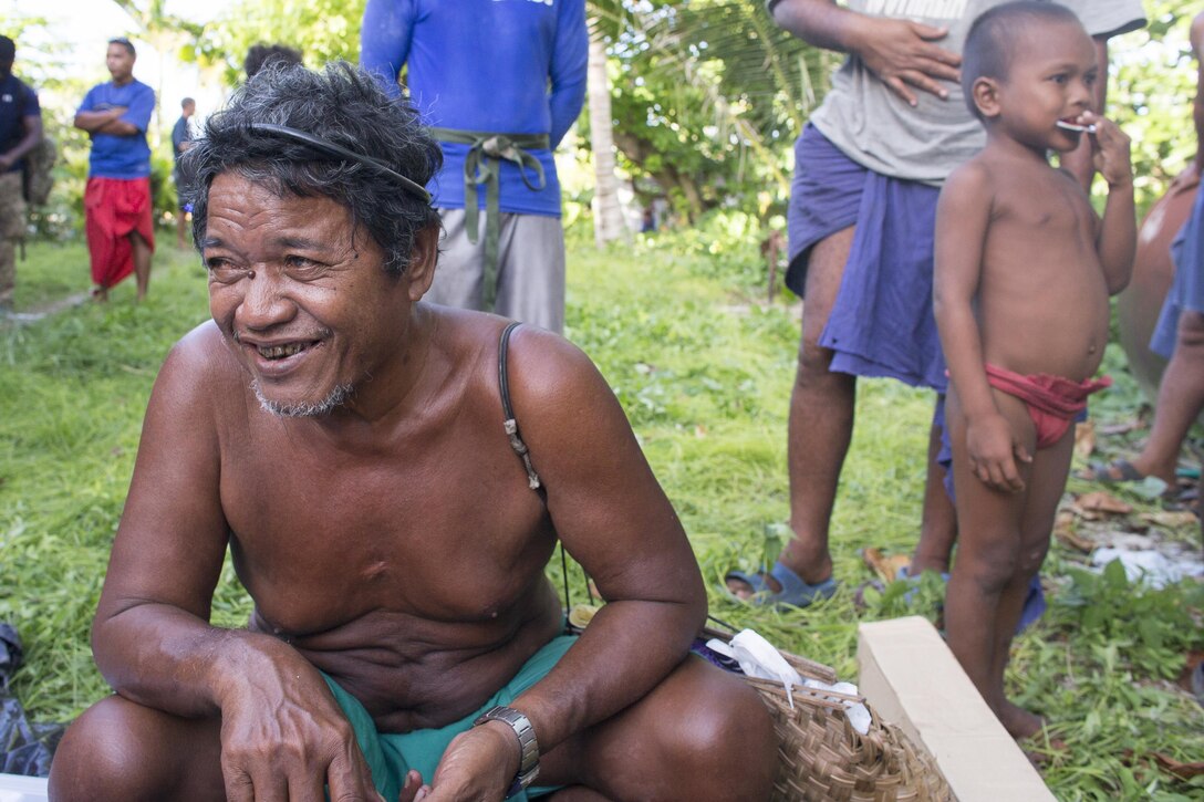 Louis Mangtau, chief of Fais Island, smiles as he sorts through supplies that were dropped during Operation Christmas Drop 2015, Dec. 8, 2015, at Fais Island, Federated States of Micronesia. Operation Christmas Drop is a humanitarian/disaster relief training event where C-130 crews provide critical supplies to 56 islands throughout the Commonwealth of the Northern Marianas, Federated States of Micronesia and Republic of Palau. This year marks the first ever trilateral execution that includes air support from the U.S. Air Force, Japan Air Self-Defense Force and the Royal Australian Air Force. (U.S. Air Force photo by Osakabe Yasuo/Released)