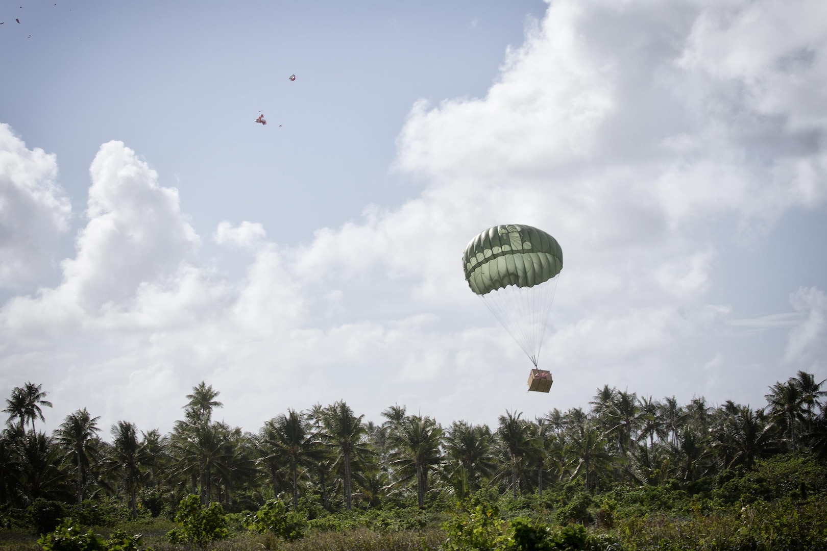 A low-cost, low-altitude bundle filled with donated goods and supplies drops on the island of Fais during Operation Christmas Drop 2015. Operation Christmas Drop is the Department of Defense's longest running humanitarian airdrop mission. This year marks the first ever trilateral Operation Christmas Drop where the U.S. Air Force, Japan Air Self-Defense Force and the Royal Australian Air Force work together to provide critical supplies to 56 Micronesian islands. (U.S. Air Force photo by Osakabe Yasuo/Released)