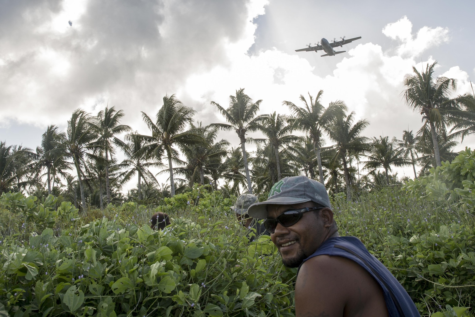 Islanders from Fais sit down to wait for the bundle drop during Operation Christmas Drop 2015, at Fais Island, Federated States of Micronesia, Dec. 8, 2015. A C-130 Hercules assigned to the 36th Airlift Squadron delivered over 800 pounds of supplies to the island of Fais during Operation Christmas Drop 2015. This year marks the first ever trilateral Operation Christmas Drop where the U.S. Air Force, Japan Air Self-Defense Force and the Royal Australian Air Force work together to provide critical supplies to 56 Micronesian islands. (U.S. Air Force photo by Osakabe Yasuo/Released)