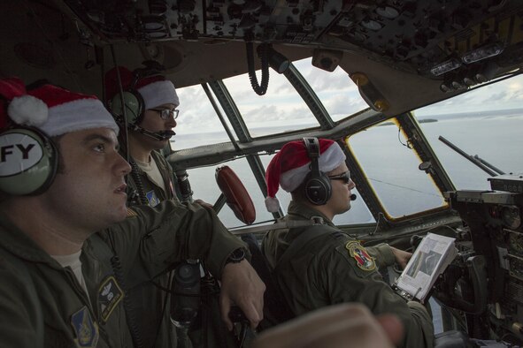 Crew members with the 36th Airlift Squadron fly over Ettal Atoll, Federated States of Micronesia, Dec. 9, 2015, during Operation Christmas Drop. This is a humanitarian aid/disaster relief training event where C-130 aircrews perform low-cost low-altitude airdrops on unsurveyed drop zones while providing critical supplies to 56 islands throughout the Commonwealth of the Northern Marianas, Federated States of Micronesia and Republic of Palau. It highlights the U.S. and allied airpower capabilities to orient and respond to activities in peacetime and crisis. In addition to delivering critical supplies to those in need, Operation Christmas Drop provides specific training to U.S. and allied aircrews, enabling theater-wide airpower. (U.S. Air Force photo by Osakabe Yasuo/Released)