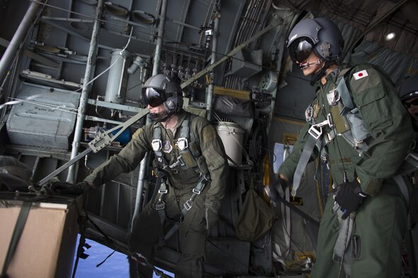 U.S. Air Force  Staff Sgt. Ren Forbes, 36th Airlift Squadron loadmaster, and Japan Air Self-Defense Force Tech. Sgt. Yuta Enoki, 402nd Squadron C-1 loadmaster, prepare for drop a low-cost, low-altitude bundle to Lukunor atoll, Federated States of Micronesia, Dec. 9, 2015, during  Operation Christmas Drop. This year marks the 64th year of Operation Christmas Drop, which began in 1952, marking it the world's longest running airdrop mission. This is the first ever trilateral training event that includes additional air support from JASDF and Royal Australian Air Force C-130 aircrews. (U.S. Air Force photo by Osakabe Yasuo/Released)