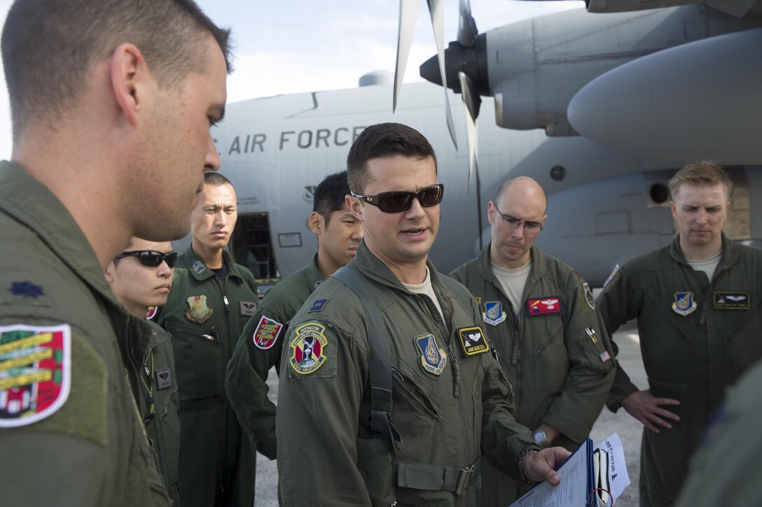 U.S. Air Force Capt. John Menezes, 36th Airlift Squadron C-130 pilot,  gives a pre-flight briefing to U.S. and Japan Air Self-Defense Force members at Andersen Air Force Base, Guam, Dec. 9, 2015, during Operation Christmas Drop 2015. It is the longest-running Department of Defense humanitarian airdrop operation with 2015 being the first trilateral execution with support from JASDF and Royal Australian Air Force. (U.S. Air Force photo by Osakabe Yasuo/Released)