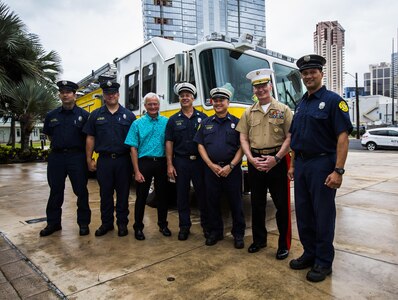 Lt. Gen. John A. Toolan (right), commander, U.S. Marine Corps Forces, Pacific, and Mayor Kirk Caldwell (left), City & County of Honolulu, take a picture with the Honolulu Police Department after the First Responder Recognition Ceremony at the Neal S. Blaisdell Center, in Honolulu, Dec. 18, 2015. Various individuals from the Honolulu Emergency Services Department, Honolulu Fire Department, and Honolulu Police Department were recognized for their heroic, selfless actions while responding to a mishap involving an MV-22 tilt-rotor aircraft. 