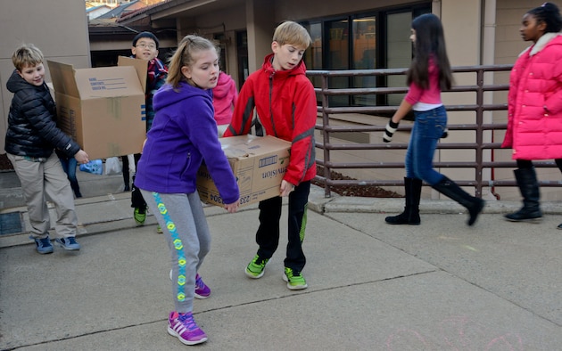Student council members from the Osan American Elementary School carry donated items on Osan Air Base, Republic of Korea, Dec. 17, 2015. The students organized and collected donations to help spread holiday cheer through comradery and philanthropy. (U.S. Air Force photo/Senior Airman Kristin High)