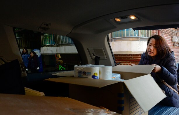 Jee Lee, MyungJin Orphanage volunteer unloads a box of donations at the MyungJin Orphanage in Seoul, Republic of Korea, Dec. 17, 2015. The orphanage houses more than 80 children, varying from a few weeks old to college age. (U.S. Air Force photo/Senior Airman Kristin High)