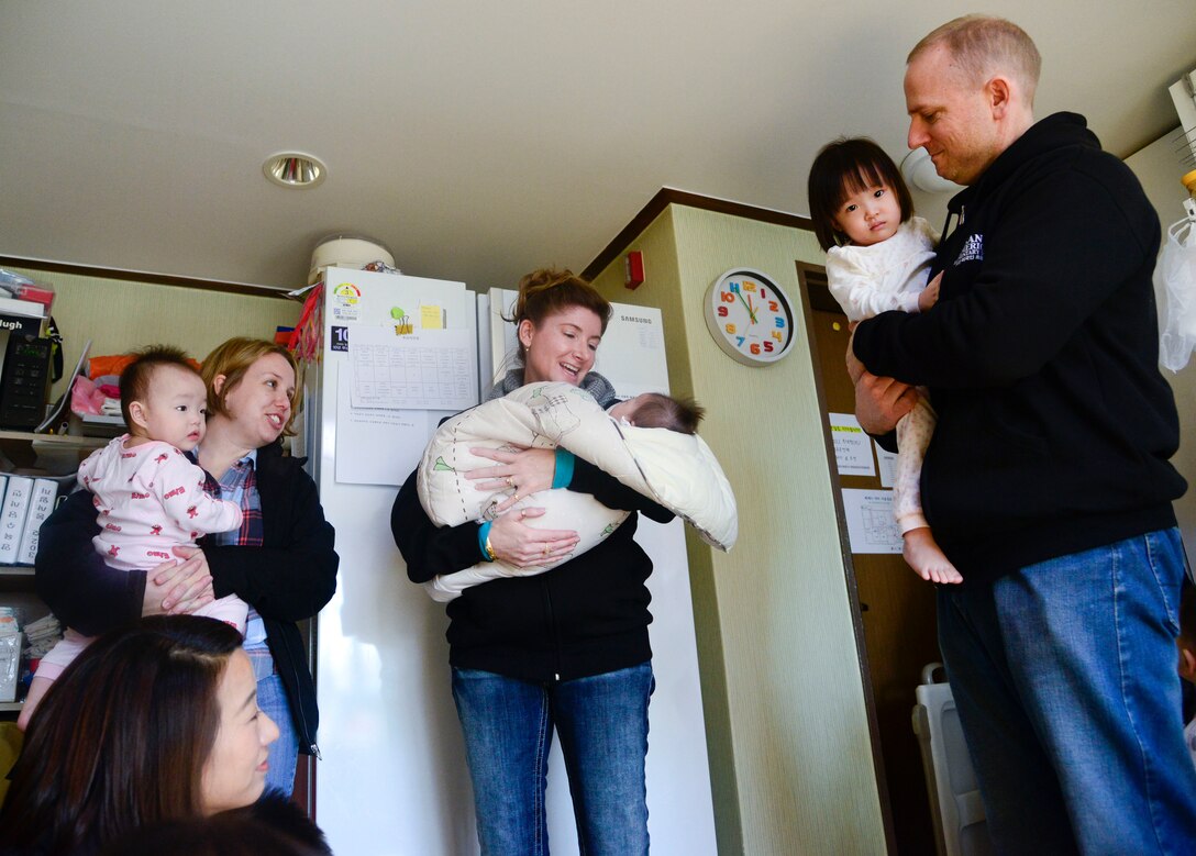 Osan American Elementary School student council advisors hold children from the MyungJin Orphanage in Seoul, Republic of Korea, Dec. 17, 2015. The OAES student council donated more than 20 boxes of essential items to the through their “5 Days of Christmas” drive. The orphanage houses more than 80 children, varying from a few weeks old to college age. (U.S. Air Force photo/Senior Airman Kristin High)