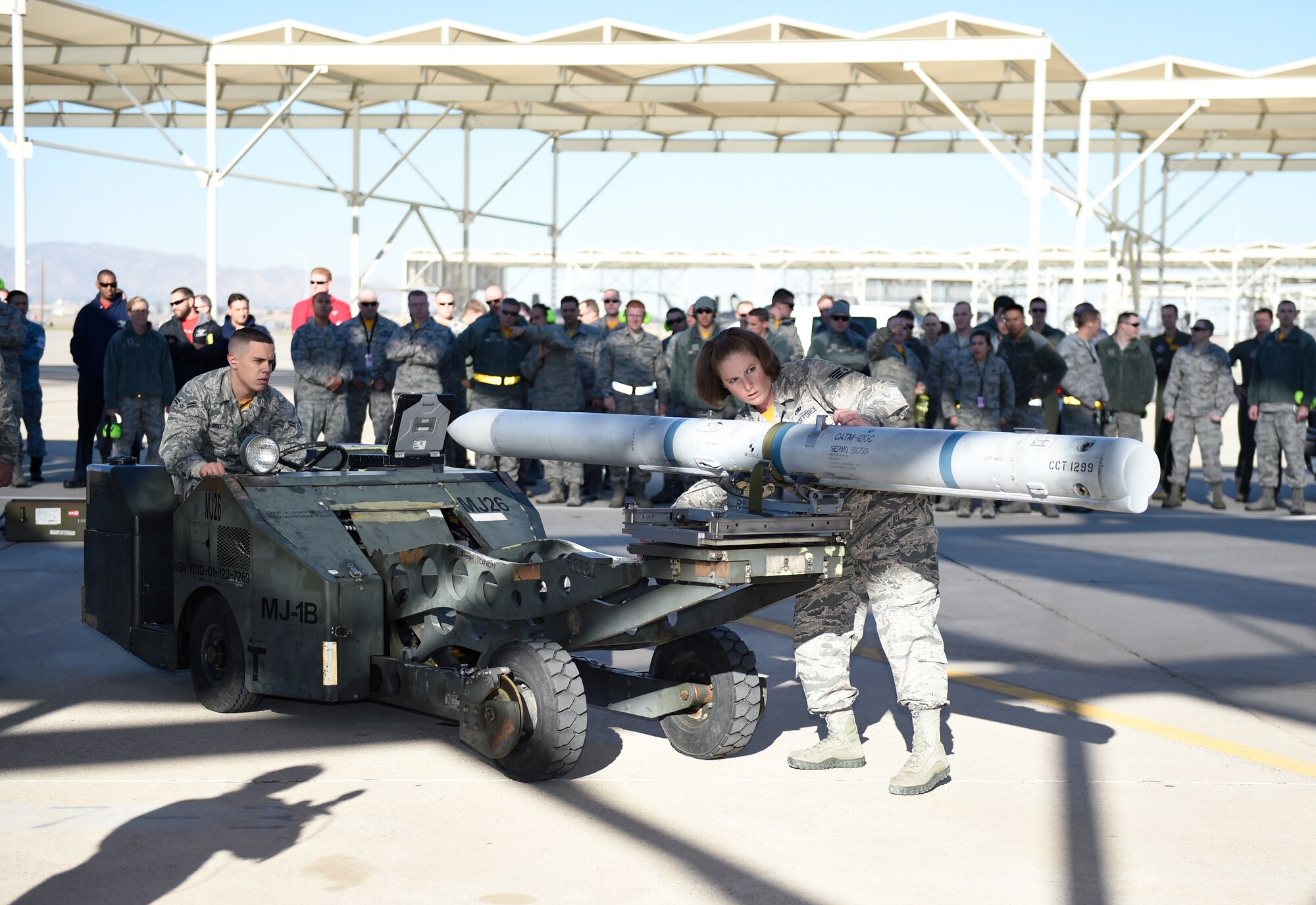 Airman 1st Class Matthew Wolfe, left, and Staff Sgt. Amy Zmak, 61st Aircraft Maintenance Unit weapons load crew members, prepare to load an F-35 Lightning ll during the 4th quarter weapon's loading competition Dec. 18 at Luke Air Force Base, Ariz. This quarter featured the first time the F-35 was used in the competition against the F-16 Fighting Falcon at Luke. Three man crews from the 61st AMU, 309th AMU, 310th AMU, and the 425th AMU went head to head to earn this quarters win. (U.S. Air Force photo by Staff Sgt. Staci Miller)