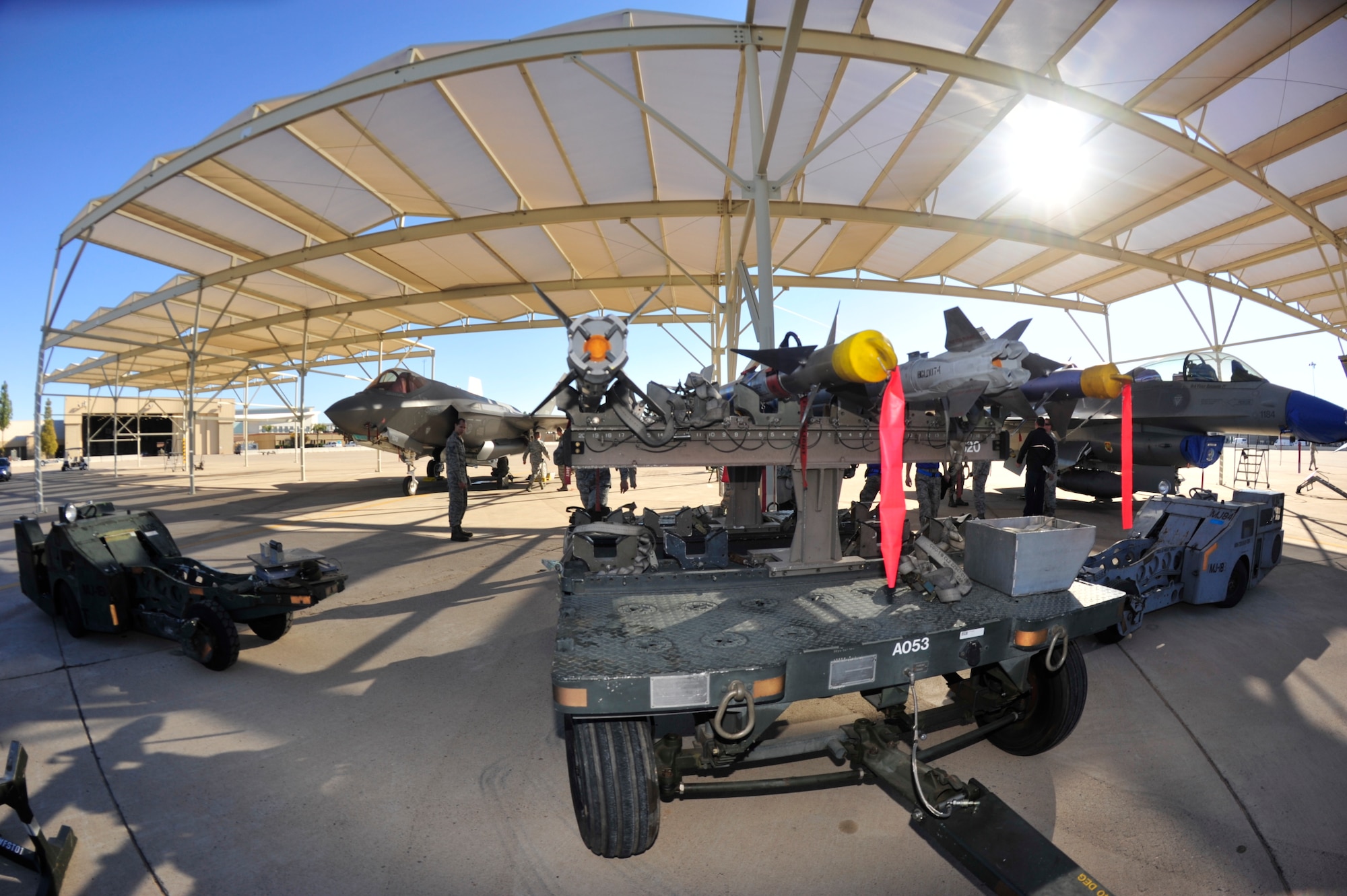 Weapons load crew members from the 61st Aircraft Maintenance Unit, 309th AMU, 310th AMU, and the 425th compete during the 4th quarter weapon's loading competition Dec. 18 at Luke Air Force Base, Ariz. This quarter featured the first time the F-35 was used in the competition against the F-16 Fighting Falcon at Luke. (U.S. Air Force photo by Senior Airman Grace Lee)