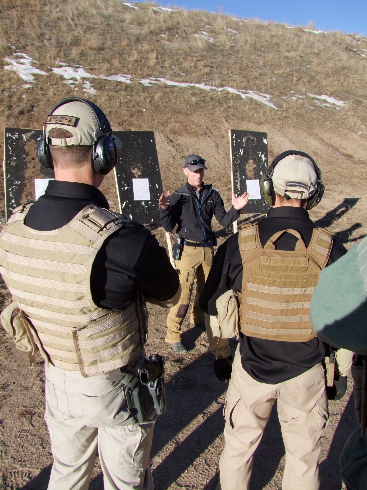 First Lt. Dalton Bridgers (middle) talks with members of the Air Force Academy's Combat Shooting Team about marksmanship fundamentals at the Academy's firing range, Dec. 5, 2015. (U.S. Air Force photo)

