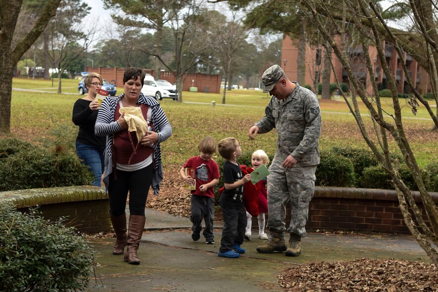 The child of Chaplain (Capt.) Devid Blevins, 4th Fighter Wing chaplain, delivers a stocking, Dec. 17, 2015, at Seymour Johnson Air Force Base, North Carolina. Members of the 4th FW Chaplain Corps delivered 200 holiday stockings to Airmen living in the dorms. (U.S. Air Force photo/Airman Shawna L. Keyes)