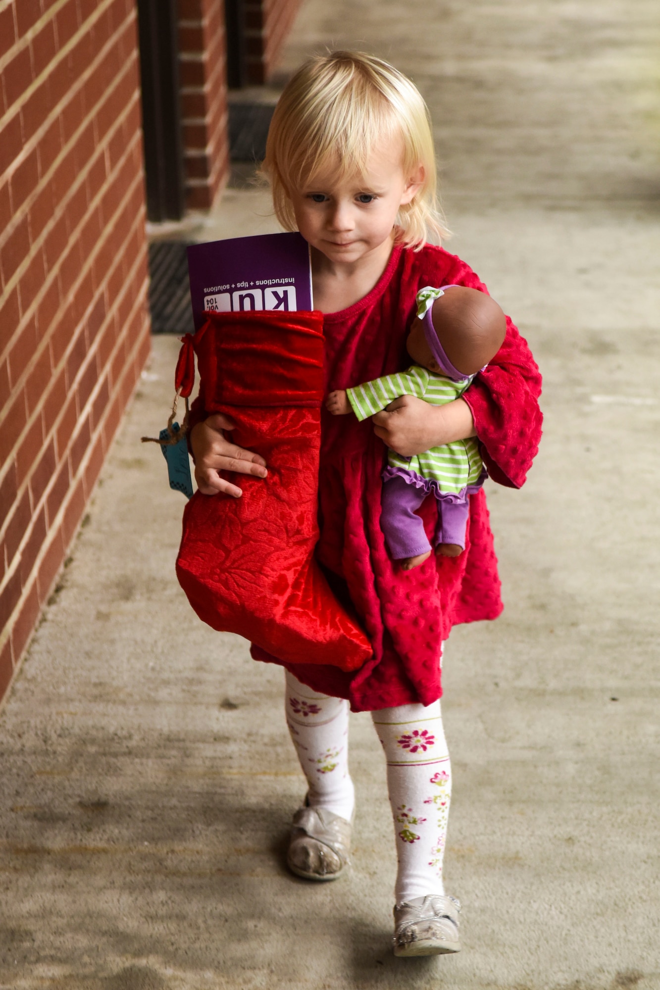 The child of Chaplain (Capt.) Devid Blevins, 4th Fighter Wing chaplain, delivers a stocking, Dec. 17, 2015, at Seymour Johnson Air Force Base, North Carolina. Members of the 4th FW Chaplain Corps delivered 200 holiday stockings to Airmen living in the dorms. (U.S. Air Force photo/Airman Shawna L. Keyes)