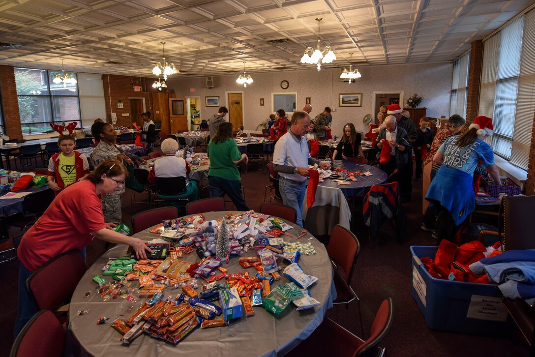 Volunteers place items in holiday stockings for Airmen living in the dorms, Dec. 17, 2015, at Seymour Johnson Air Force Base, North Carolina. More than 15 volunteers from the 4th Fighter Wing Base Chapel filled the stockings. (U.S. Air Force photo/Airman Shawna L. Keyes)