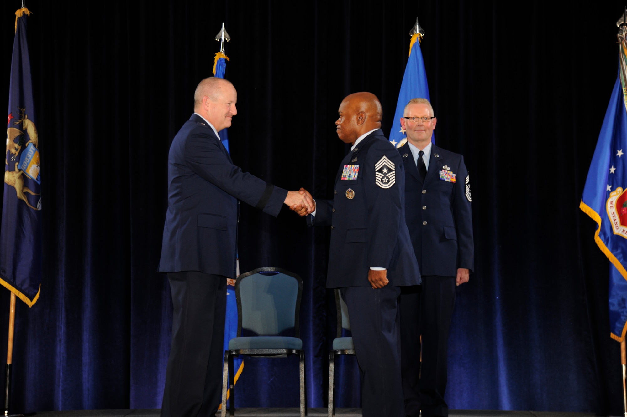 Brig. Gen. John D. Slocum, 127th Wing commander, shakes hands with newly-appointed 127th Wing Command Chief Master Sgt. Tony Whitehead during the 127th Wing Annual Awards Ceremony at Selfridge Air National Guard Base, Mich., Dec. 5, 2015. Behind Slocum and Whitehead is Chief Master Sgt. Robert Dobson, who completed his service as the Wing’s command chief during the ceremony. (U.S. Air National Guard photo by Senior Airman Ryan Zeski)