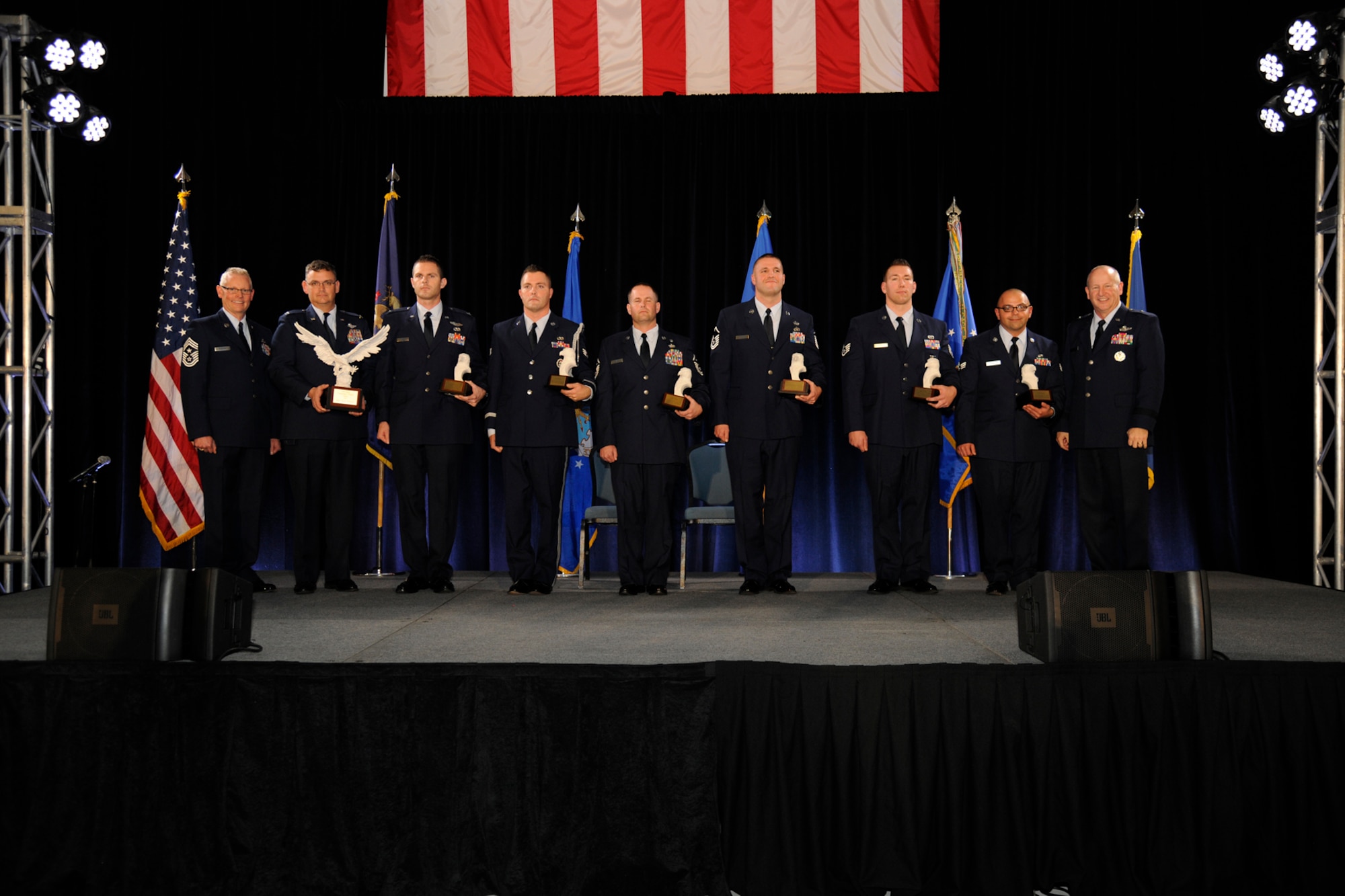 The 127th Wing’s Outstanding Airmen of Year are honored on stage during the Wing’s Annual Awards Ceremony at Selfridge Air National Guard Base, Mich. Dec. 5, 2015. Pictured are: 127th Wing Command Chief Master Sgt. Robert Dobson; Col. David Brooks, who accepted the Wing Commander’s Trophy on behalf of Major David Nicholson; Capt. Russell Overton; Senior Airman Shane Shaltry; Master Sgt. Lyle Black; Master Sgt. Christopher Tarquino; Staff Sgt. Michael Rygwelski; Senior Airman Matthew Thornton; and Brig. Gen. John D. Slocum, 127th Wing commander. (U.S. Air National Guard photo by Senior Airman Ryan Zeski)