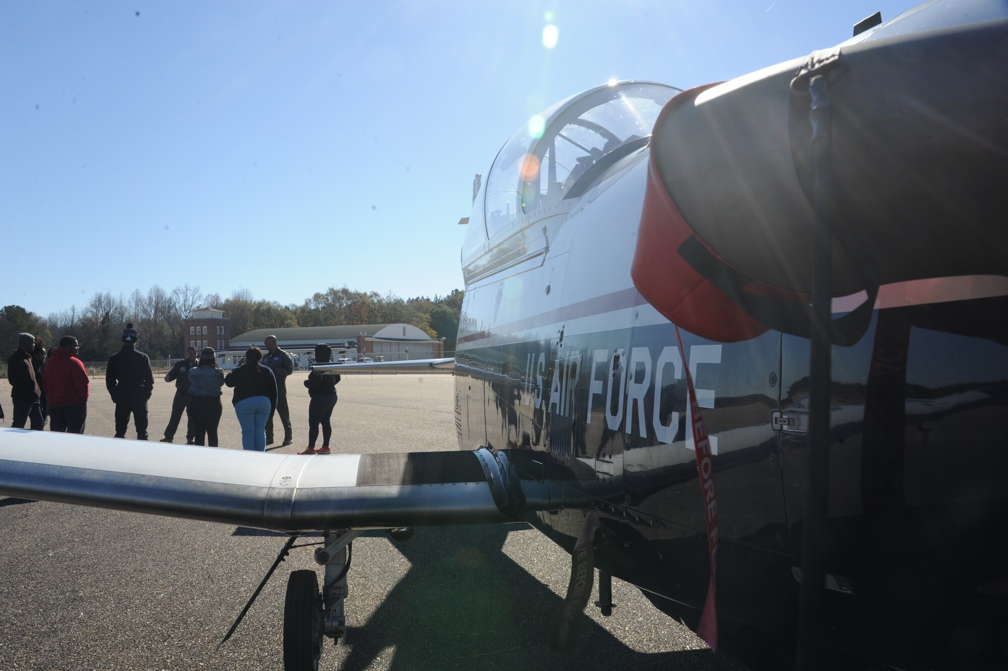 Air Force pilots talk to Eyes Above the Horizon participants in front of a T-6 Texan aircraft Dec. 5, 2015, at the Tuskegee Institute National Historic Museum, Tuskegee, Alabama. Participants learned about different types of aircraft and how to begin a career in aviation. (U.S. Air Force photo by Airman 1st Class Alexa Culbert)