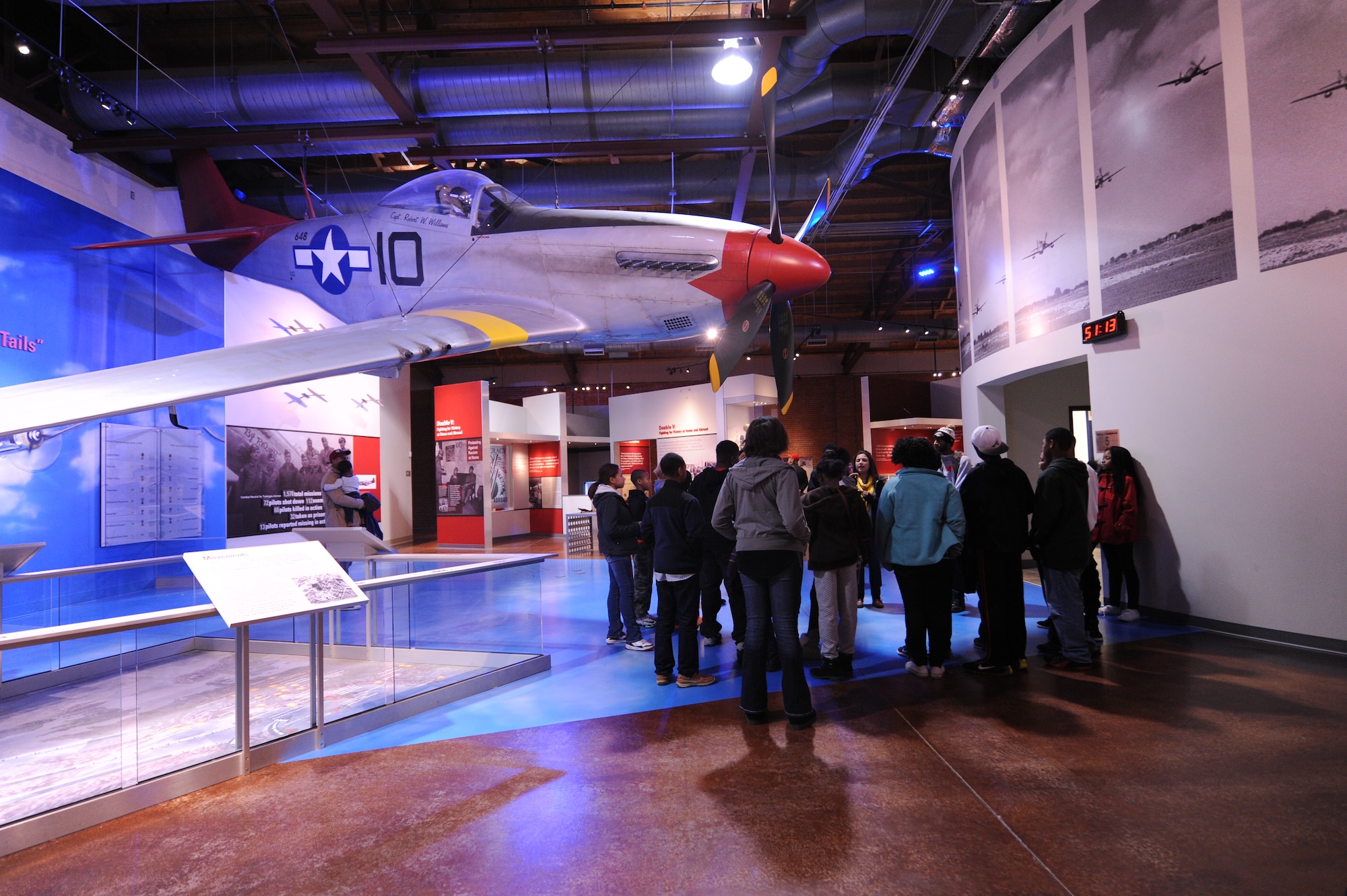 Eyes Above the Horizon participants gather under a North American P-51 Mustang static display Dec. 5, 2015, at the Tuskegee Institute National Historic Museum, Tuskegee, Alabama. Participants learned about the Tuskegee Airman during the program in hopes of instilling ambition to achieve higher accomplishments and maybe consider a career in aviation. (U.S. Air Force photo by Airman 1st Class Alexa Culbert)