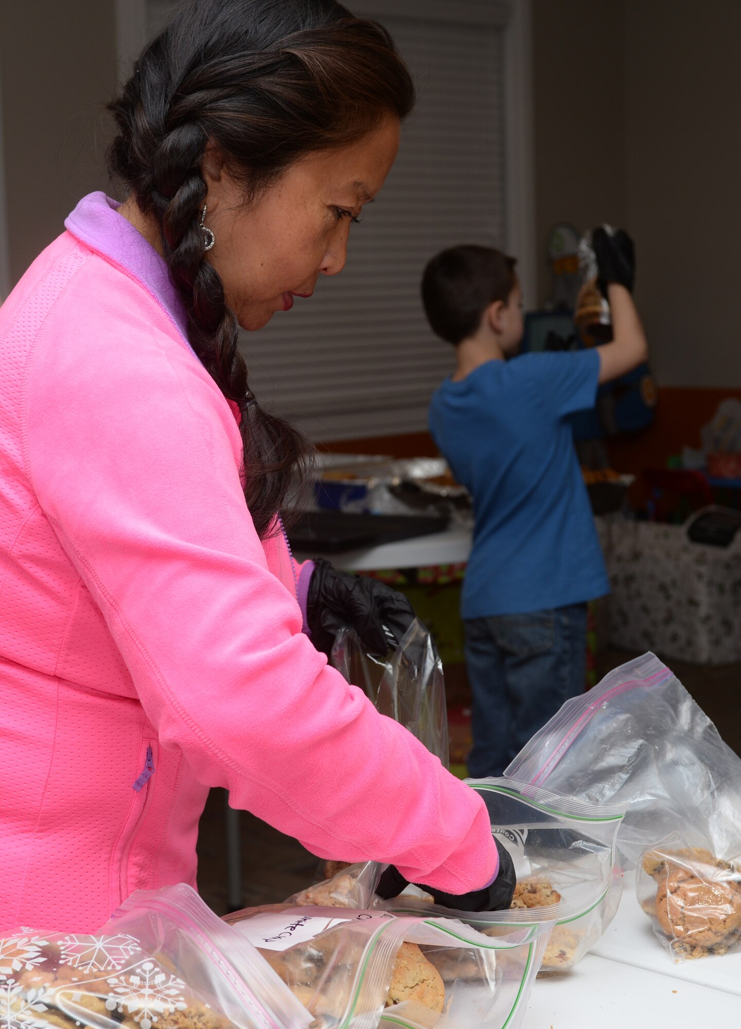 Lisa Shirey packages baked goods at Ellsworth Air Force Base, S.D., Dec. 13, 2015. The Enlisted Spouse’s Club prepared and collected more than 6,000 baked goods for Airmen residing in the dorms. (U.S. Air Force photo by Airman Donald C. Knechtel/Released)