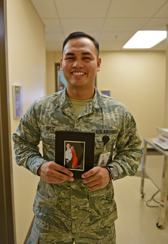 Airman 1st Class Emilcarlo Ortiz, 28th Medical Operations Squadron aerospace medical technician, stands with a photo of him and his fiancé Weynmhe at Ellsworth Air Force Base, S.D., Nov. 20, 2015. His family currently resides in the Philippines, however, Ortiz uses the photo as a daily reminder of what he is thankful for. (U.S. Air Force photo by Airman 1st Class James L. Miller/Released)