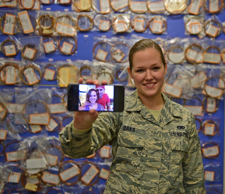Airman 1st Class Stacy Oaks, 28th Maintenance Squadron electrical and environmental systems apprentice, stands with a photo of her and her husband, Josh, at Ellsworth Air Force Base, S.D., Nov. 20, 2015. Even though she will not be able to go home this holiday season, Oaks is thankful she can still spend time with her husband. (U.S. Air Force illustration by Airman 1st Class James L. Miller/Released)