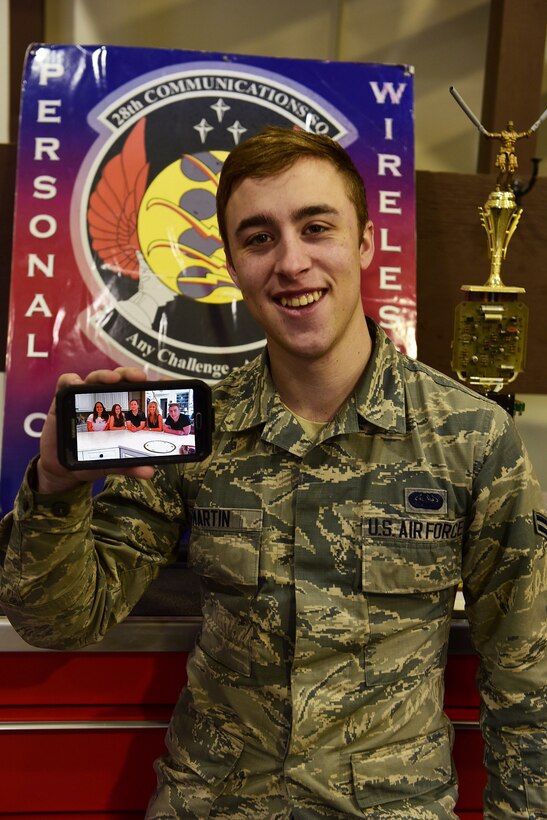 Airman 1st Class Christian Martin, 28th Communication Squadron RF transmission systems technician, shows a photo of his siblings at Ellsworth Air Force Base, S.D., Nov. 20, 2015. Martin is thankful for his siblings and the support they have given him throughout the years. (U.S. Air Force illustration by Airman 1st Class James L. Miller/Released)