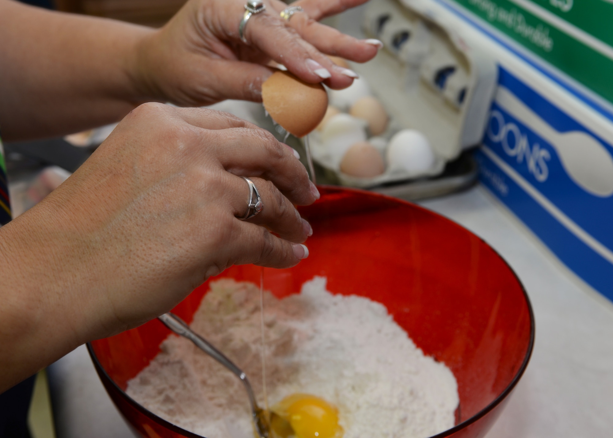 Lupe Robson, 28th Bomb Wing Staff Judge Advocate office Victim Witness Assistant Program coordinator, adds an egg to the cookie mix at Ellsworth Air Force Base, S.D. Dec. 13, 2015. The Enlisted Spouse’s Club prepared and collected more than 6,000 baked goods for Ellsworth Airmen residing in the dorms. (U.S. Air Force photo by Airman Donald C. Knechtel/Released)