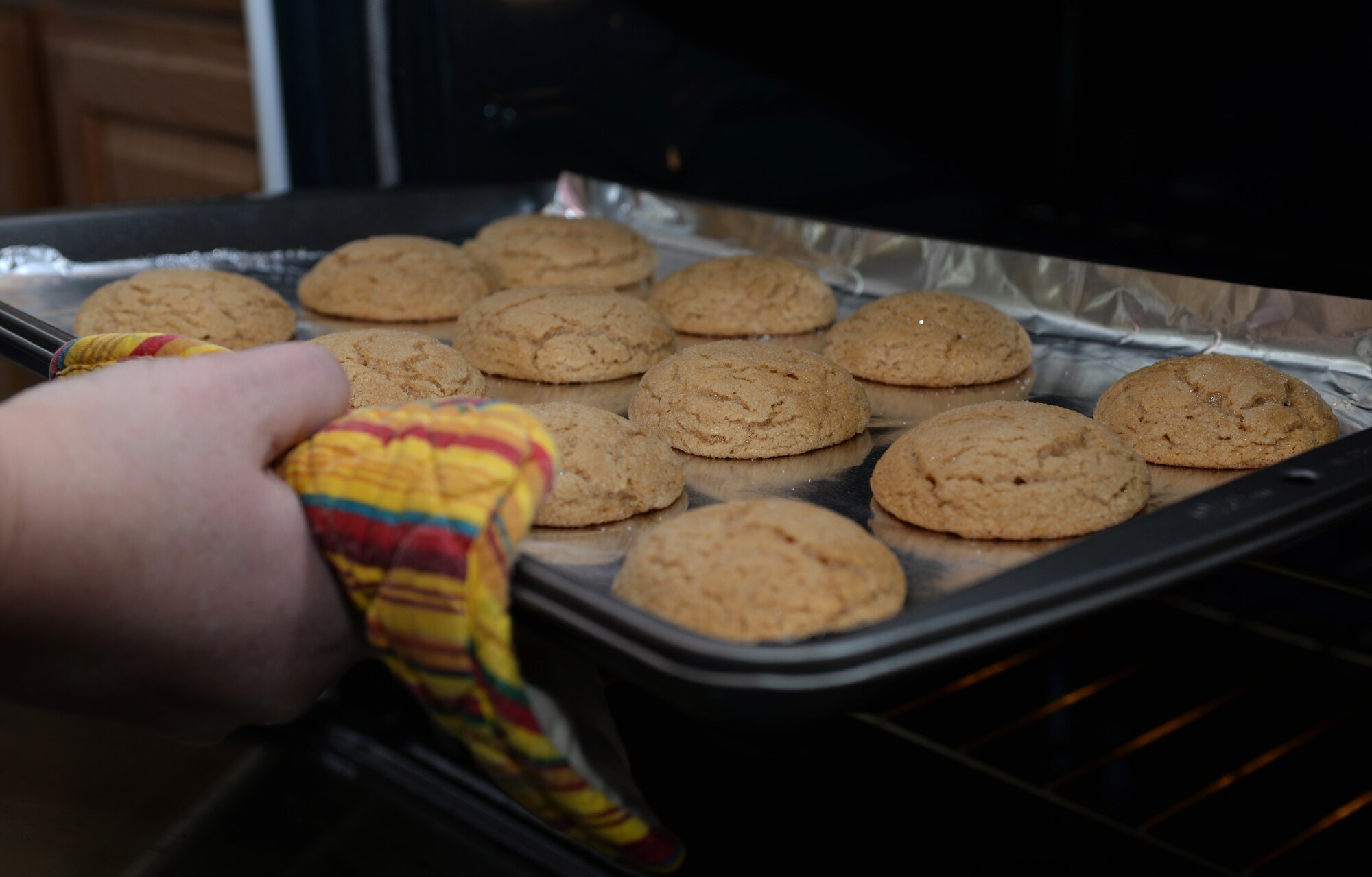 A volunteer takes out a batch of cookies for the Holiday Cookie Drive at Ellsworth Air Force Base, S.D. Dec. 13, 2015. The drive was established to bring holiday cheer to Airmen who don’t get to go home during the holidays. (U.S. Air Force photo by Airman Donald C. Knechtel/Released)