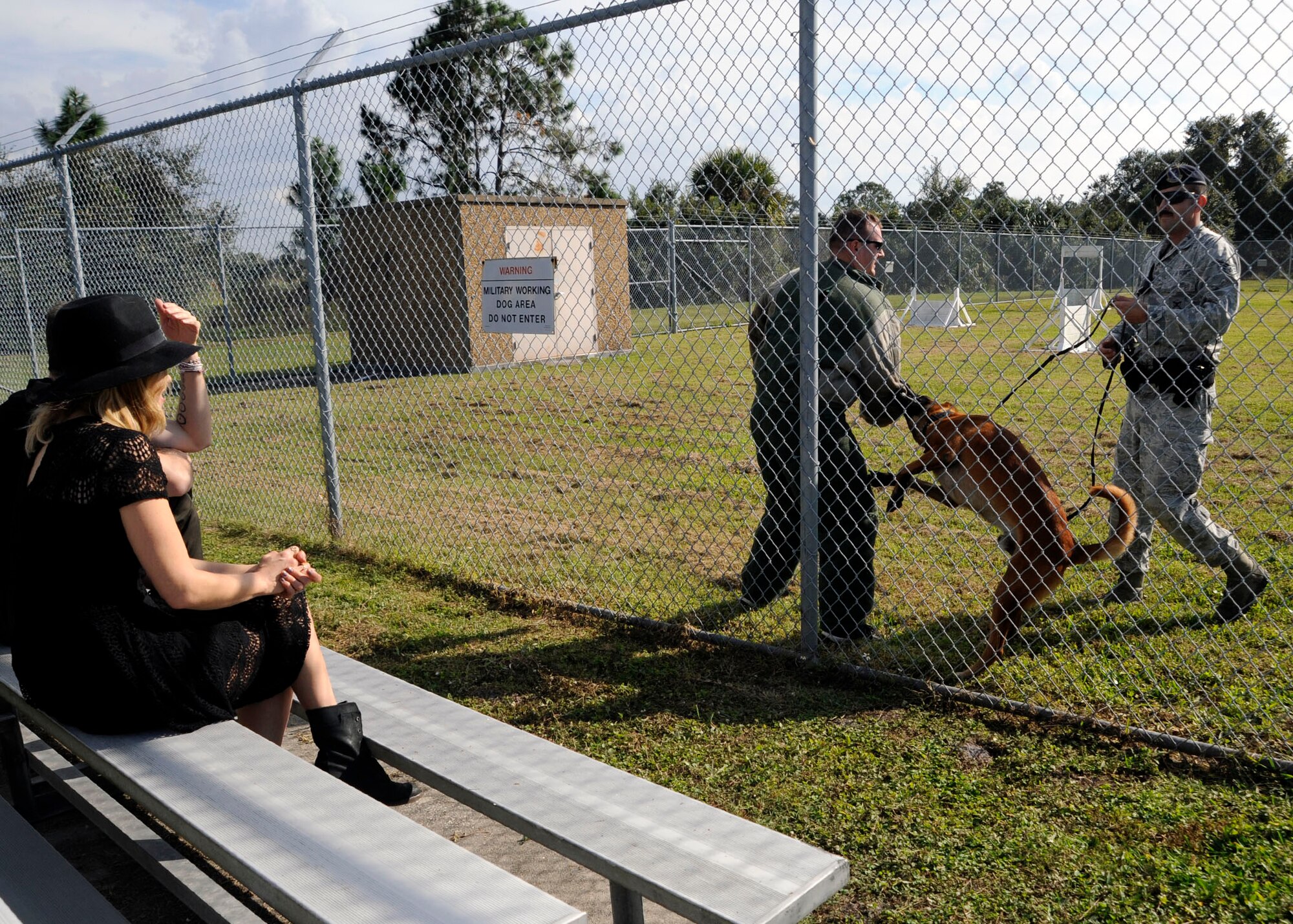 Singer Rachel Platten observes a military working dog demonstration during her visit to MacDill Air Force Base, Fla., Dec. 14, 2015. The 6th Security Forces Squadron MWD handlers performed various senarios that they use during training. (U.S. Air Force photo by Airman 1st Class Mariette M. Adams)