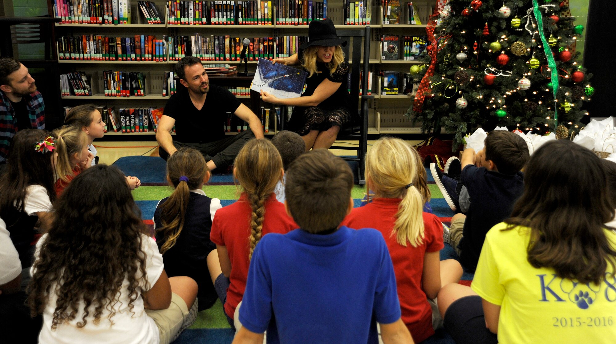Singer Rachel Platten reads to students from Tinker K-8 School to begin her visit to MacDill Air Force Base, Fla., Dec. 14, 2015. Platten also observed a military working dog demonstration and performed at the 6th Medical Group clinic during her visit. (U.S. Air Force photo by Airman 1st Class Mariette M. Adams)