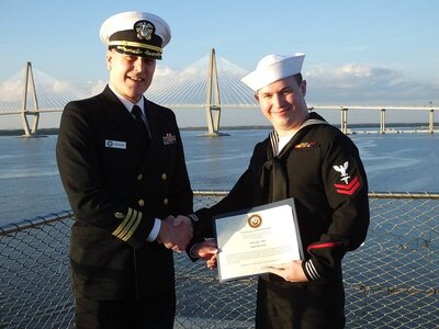 Petty Officer 2nd Class Cody Davis, right, a hospital corpsman at Naval Health Clinic Charleston, receives a Certificate of Reenlistment from Cdr. Richard Graham, director for NHCC's Clinical Support Services and department head of NHCC's laboratory. The certificate was presented during Davis's reenlistment ceremony Dec. 11, 2015 aboard the USS Yorktown, located at Patriots Point Naval & Maritime Museum in Mount Pleasant, S.C. (Navy photo/Kris Patterson)
