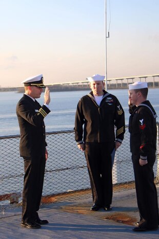 Petty Officer 2nd Class Cody Davis, right, a hospital corpsman at Naval Health Clinic Charleston, swears the Oath of Enlistment during his reenlistment ceremony Dec. 11, 2015 aboard the USS Yorktown, located at Patriots Point Naval & Maritime Museum in Mount Pleasant, S.C. Cdr. Richard Graham, left, director for NHCC's Clinical Support Services and department head of NHCC's laboratory, was the reenlisting officer. Petty Officer 1st Class Samuel Hutcheson, also a hospital corpsman at NHCC, was the master of ceremonies. (Navy photo/Steve Potter)