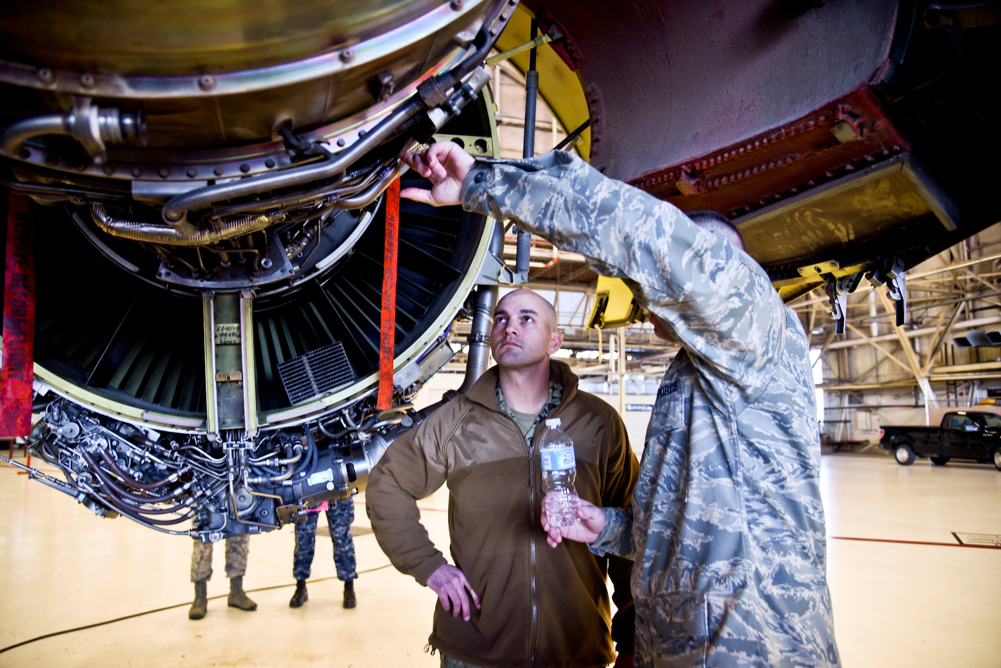 Lt. Cmdr. Jake Roberts, Navy Operations Support Center Spokane commanding officer, looks at one of the engines from a KC-135 Stratotanker as Tech Sgt. Dustin Garneau, 92nd Maintenance group hydraulics craftsman, explains how it works Dec. 16, 2015, at Fairchild Air Force Base, Wash. In support of Total Force Integration and the Host Area Agreement, Fairchild Airmen provided a base tour for NOSC Spokane leadership. (U.S. Air Force photo/Airman 1st Class Taylor Bourgeous)