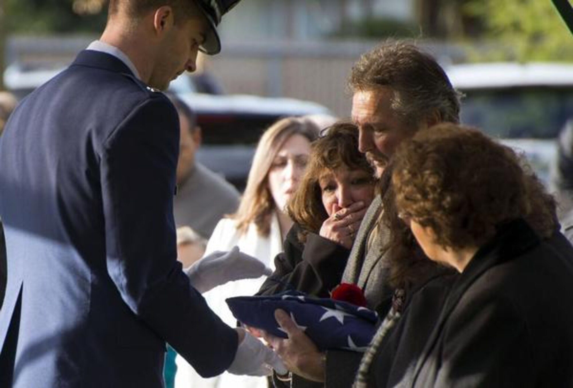 Capt. Maxfield Shea, left, Joint Base Lewis-McChord Air Force Honor Guard flag presenting officer, presents a flag to the children of 1st Lt. Joseph Moser at his burial, Dec. 11 at Woodlawn Cemetery in Ferndale, Wash. Moser died at 92 and was a World War II POW. (Air Force Photo/Senior Airman Jacob Jimenez)