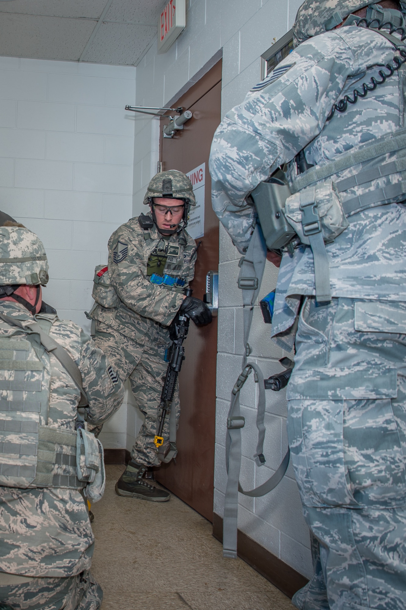 U.S. Air Force Master Sgt. Gregory Wardle, 153rd Security Forces Squadron, communicates with Airmen on the other side of a locked door, Dec. 18, 2015 at Cheyenne Air National Guard base in Cheyenne, Wyoming. Wardle and several security forces Airmen clear buildings and check for wounded after eliminating a gunman during an active shooter exercise. The scenario was in support of memorandum sent by Secretary of the Air Force Deborah James to test lockdown and active shooter procedures in response to shootings in Chattanooga, Tenn. (U.S. Air National Guard photo by Master Sgt. Charles Delano)