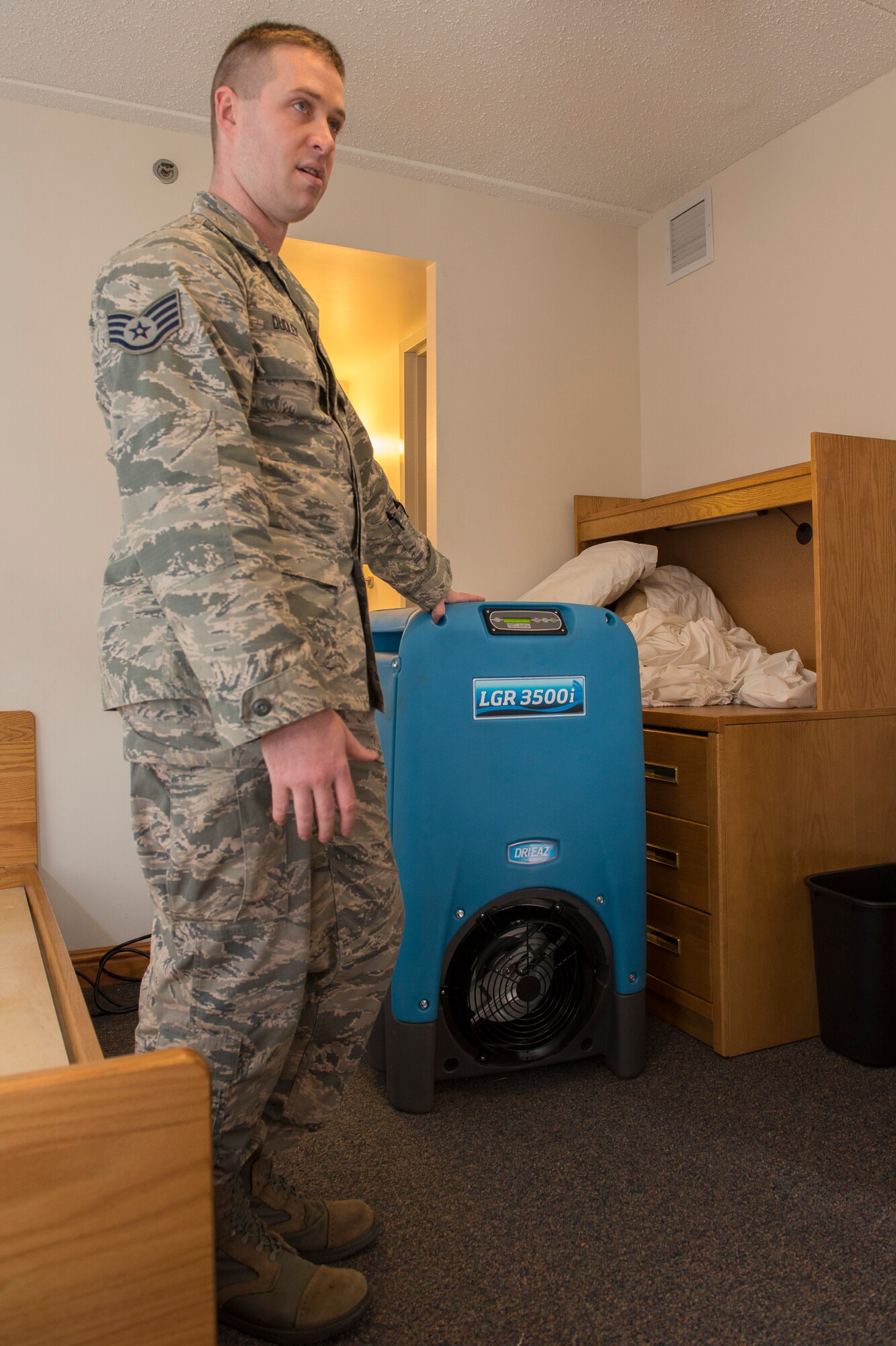 Staff Sgt. Eric Dudley, 375th Civil Engineering Squadron airman dormitory leader, teaches bay orderlies how to use the new dehumidifier, Dec. 14, 2015, Scott Air Force Base, Illinois. Bay orderlies play a key role in maintaining the dorms up to standards. (U.S. Air Force photos by Airman 1st Class Melissa Estevez)