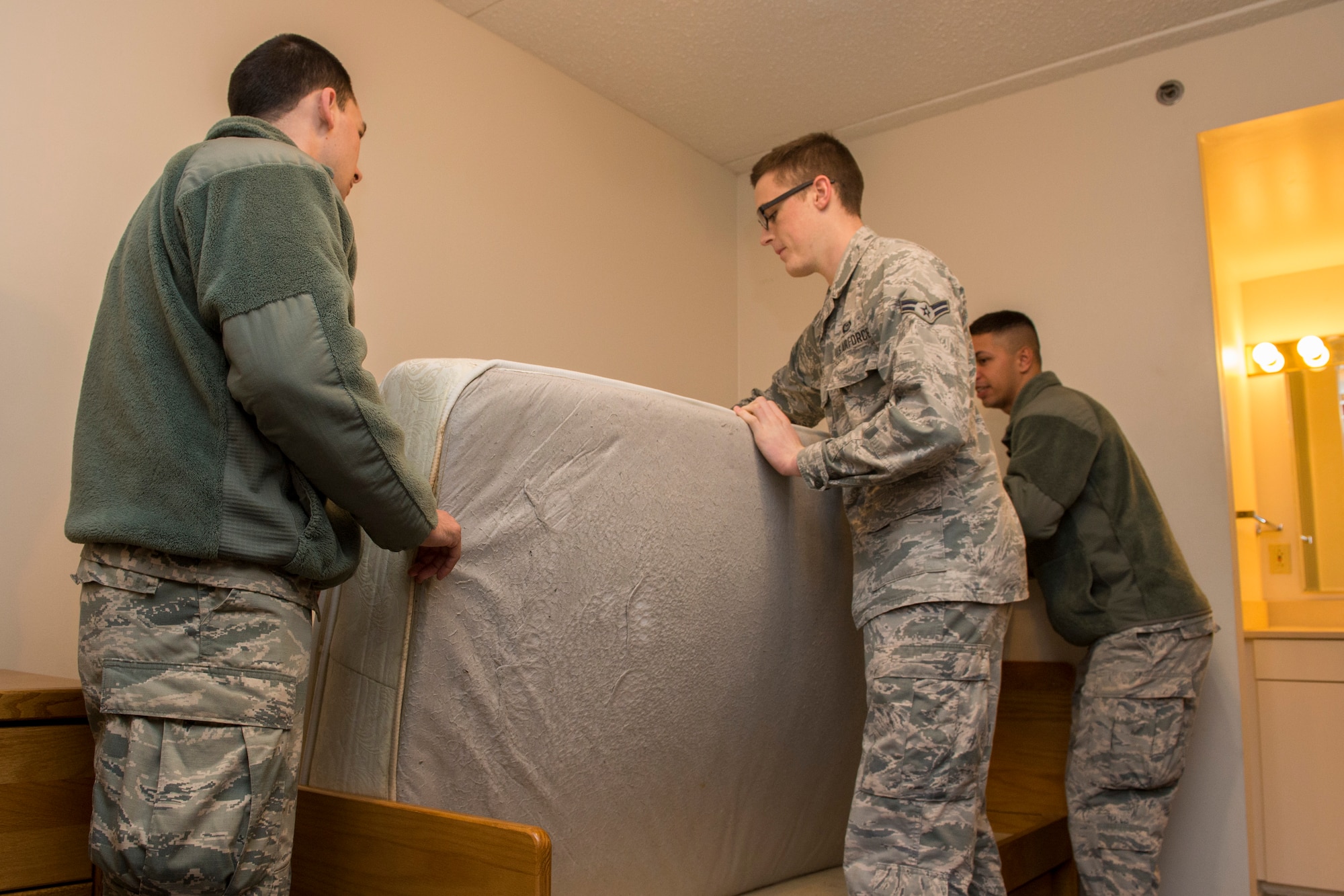 Airmen assigned to bay orderlies prepare to remove an old mattress from a dormitory, Dec. 14, 2015, Scott Air Force Base, Illinois. Airmen are selected by their respective first sergeants for clean-up duty based on a rotating schedule, which ensures all dorm residents shared the responsibility of keeping their buildings in shape. (U.S. Air Force photos by Airman 1st Class Melissa Estevez)